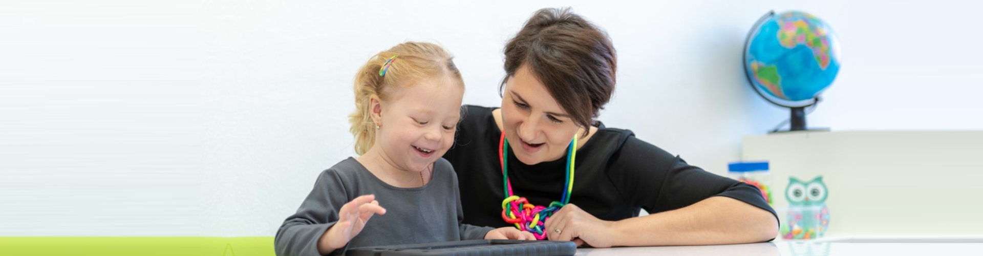 caregiver and child looking into the tablet
